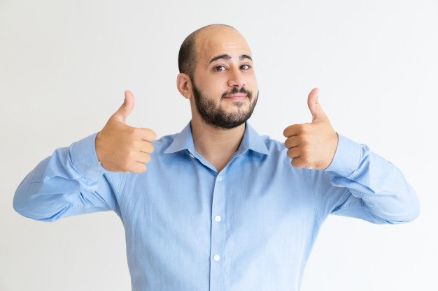 Positive man showing both thumbs up and looking at camera | Free Photo